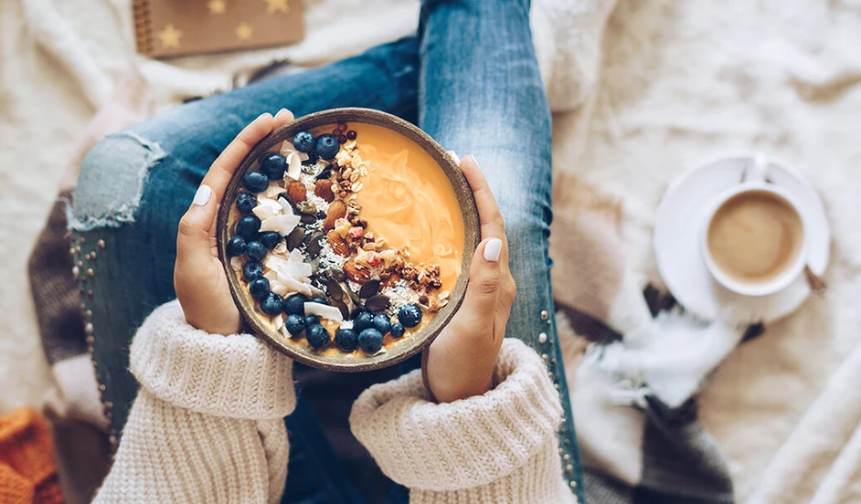 Frau hält eine Smoothie-Bowl in den Händen.