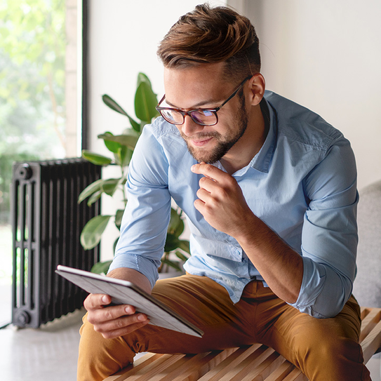 Junger Mann mit Tablet sitzend