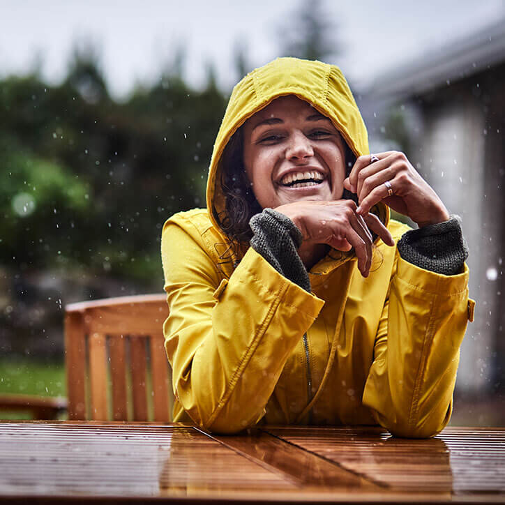 Junge Frau geschützt im Regen I Doppelherz