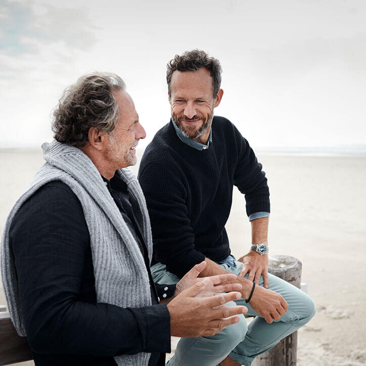 Zwei Männer im Gespräch am Strand | Doppelherz