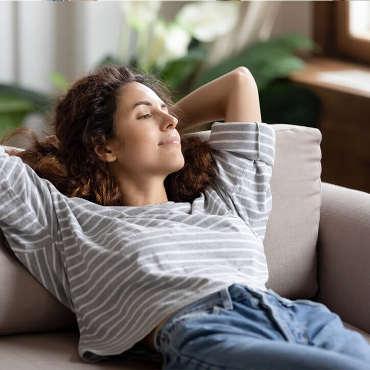 Junge Frau entspannt auf dem Sofa | Doppelherz