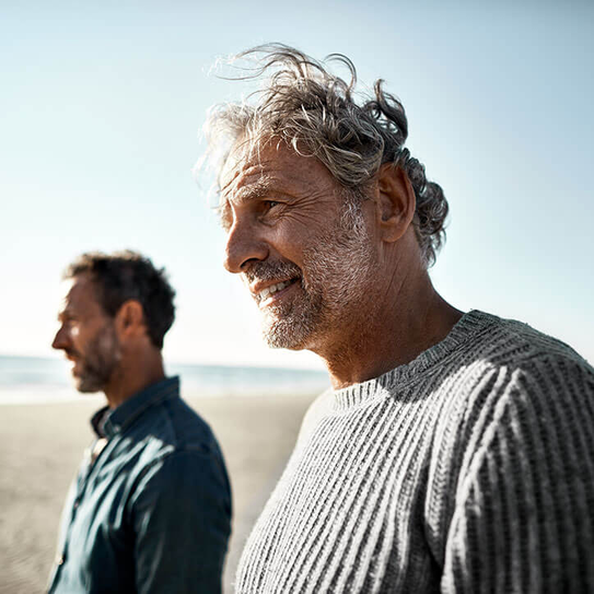 Zwei lächelnde Männer am Strand