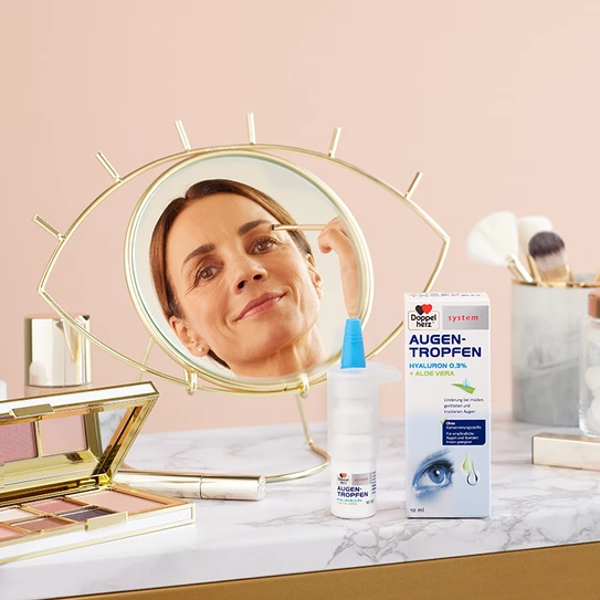 Frau guckt in den Spiegel und vor ihr steht das Produkt
