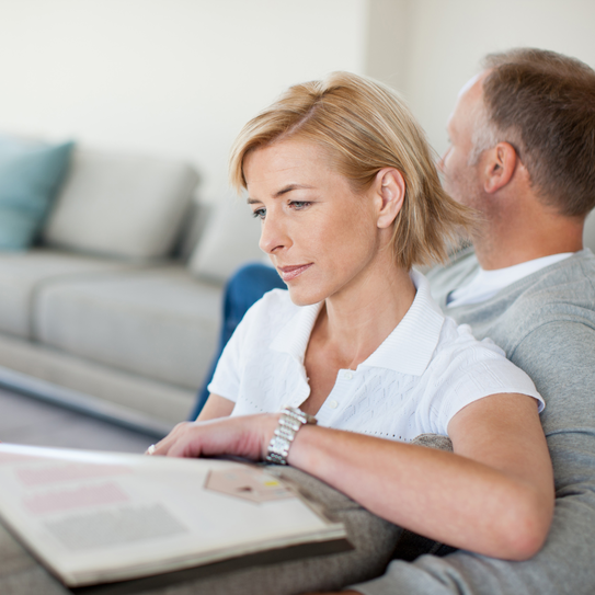 Frau liest Buch auf dem Sofa